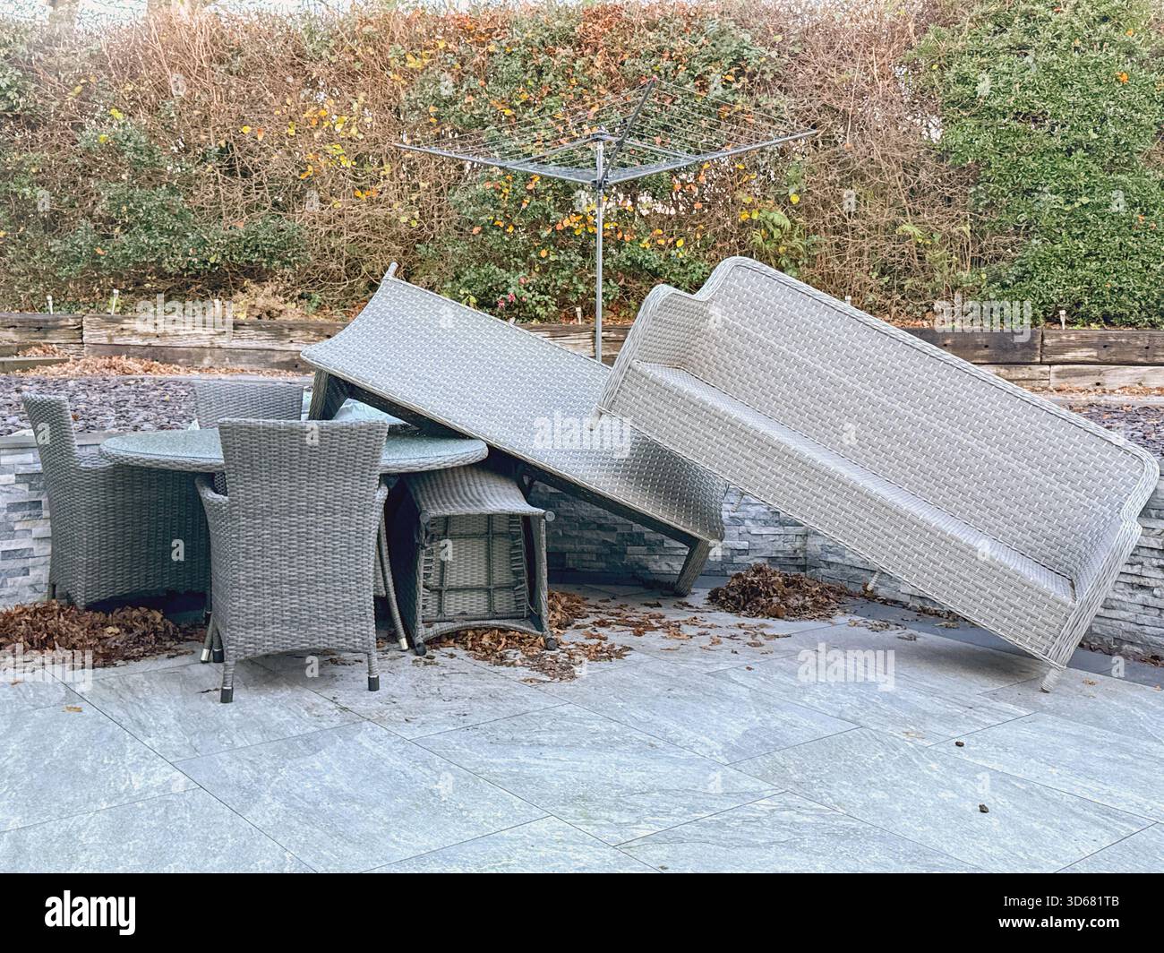 Rattan garden furniture piled up after the impact of very strong winds from a storm. No people. - Smartphone Captured Stock Image