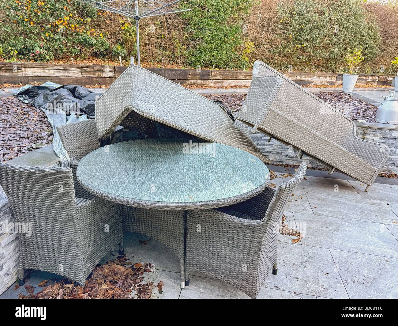 Rattan garden furniture piled up after the impact of very strong winds from a storm. No people. - Smartphone Captured Stock Image