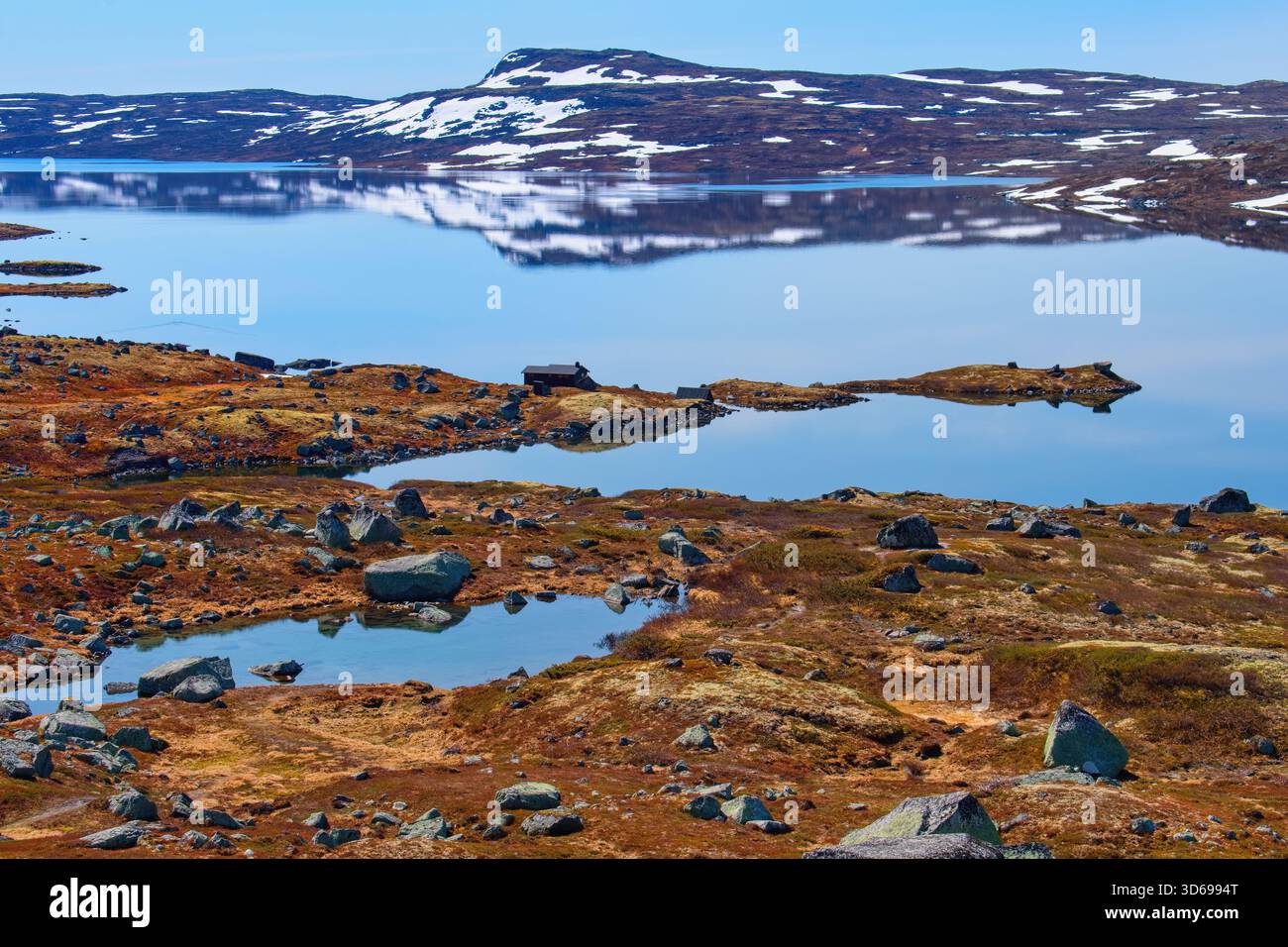 Norwegian mountain lake in snowy landscape, scenic route  Hardangervidda Stock Photo
