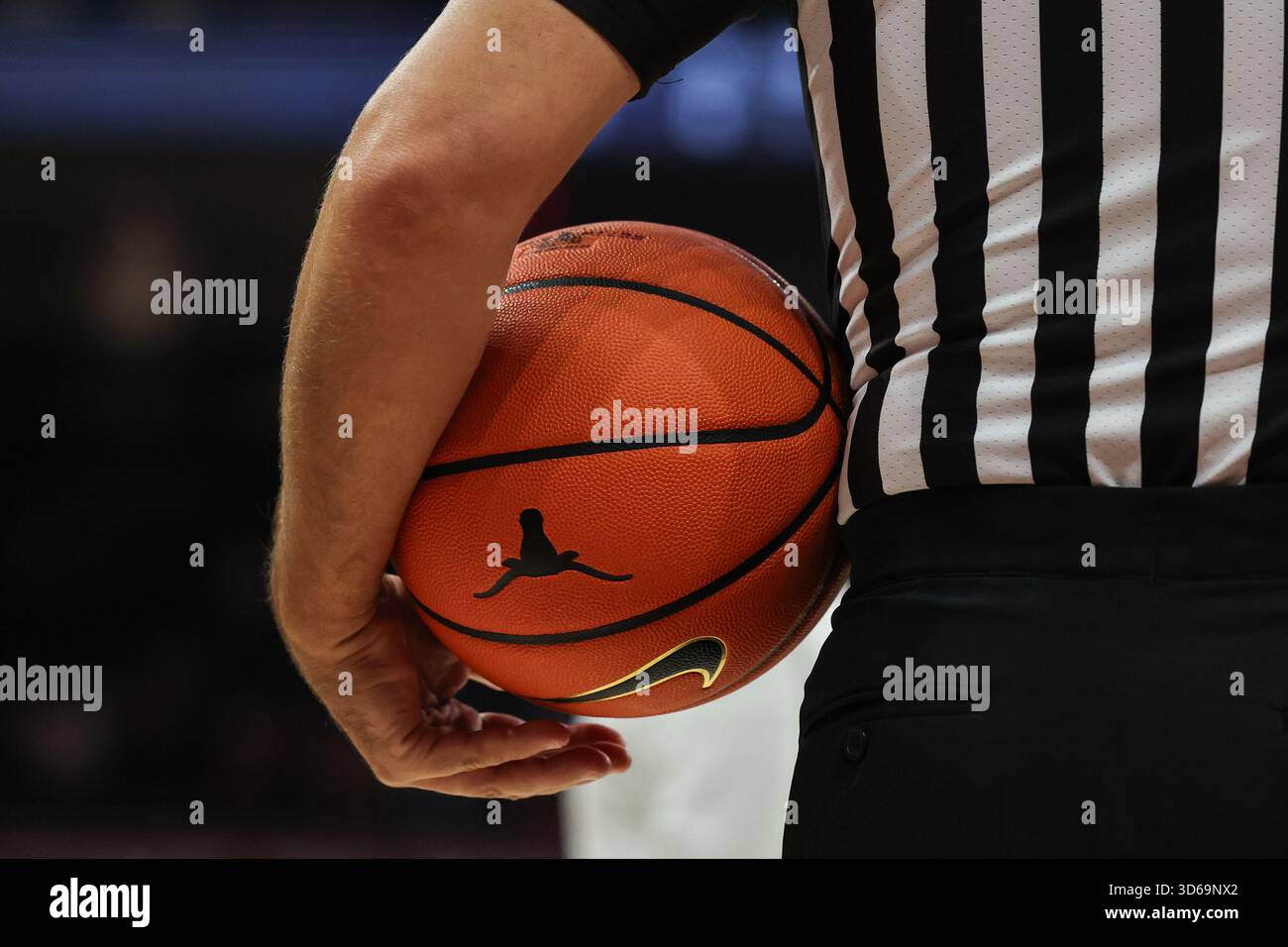 AUSTIN, TX - NOVEMBER 18: A referee holds the basketball under his arm ...