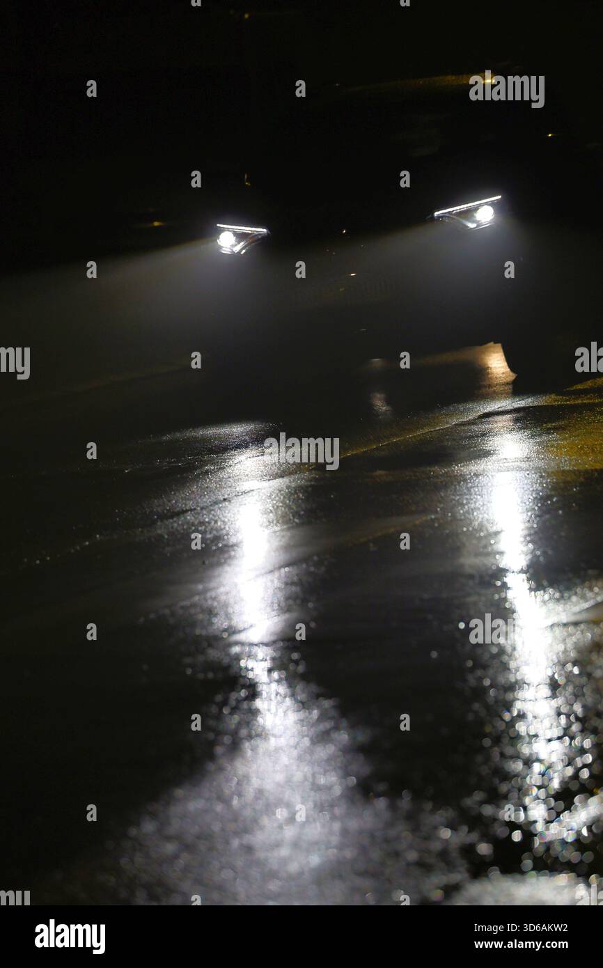 Car Headlights Reflecting on a Wet Road at Night Stock Photo - Alamy