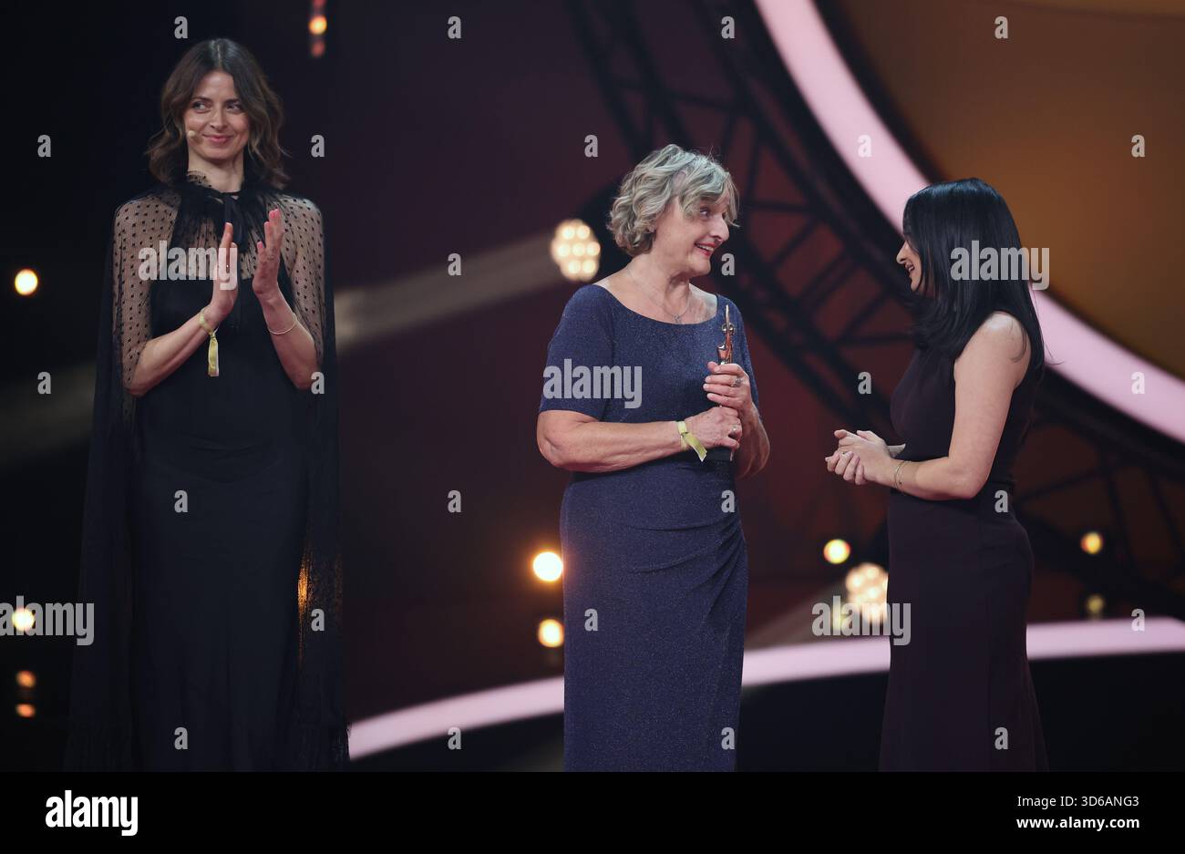 Hamburg, Germany. 19th Nov, 2025. Miriam Peters (M), 'Land-Grazien' project, accepts the award on stage during the 'Goldene Bild der Frau' ceremony at the Stage Theater an der Elbe. On the left is her laudator, model Eva Padberg. On the right is Federal Development Minister Reem Alabali-Radovan (SPD). Credit: Christian Charisius/dpa/Alamy Live News Stock Photo