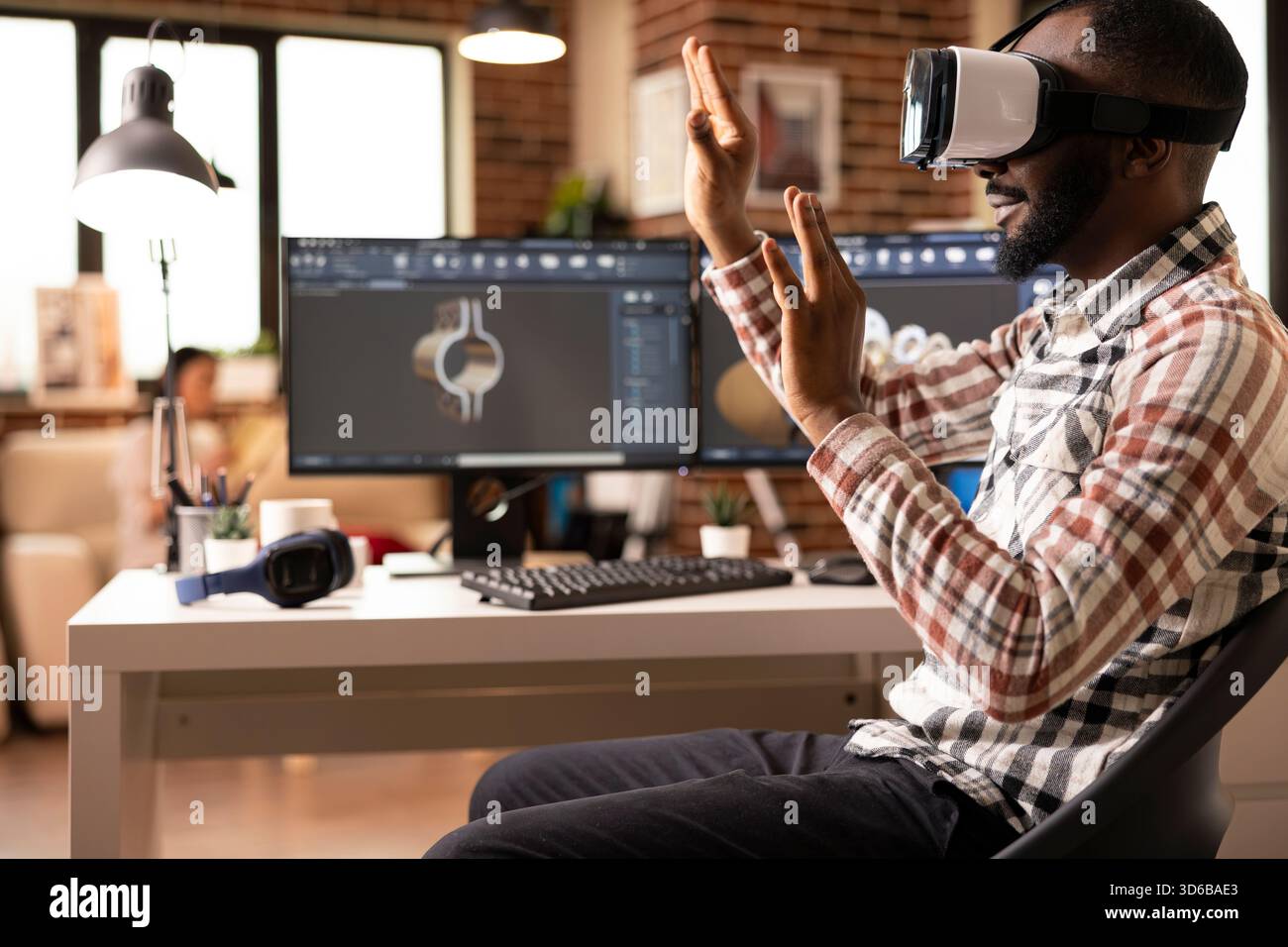 Focused black designer using virtual reality headset to develop digital building models for construction projects. Advanced immersive technology supporting interactive design review. Stock Photo