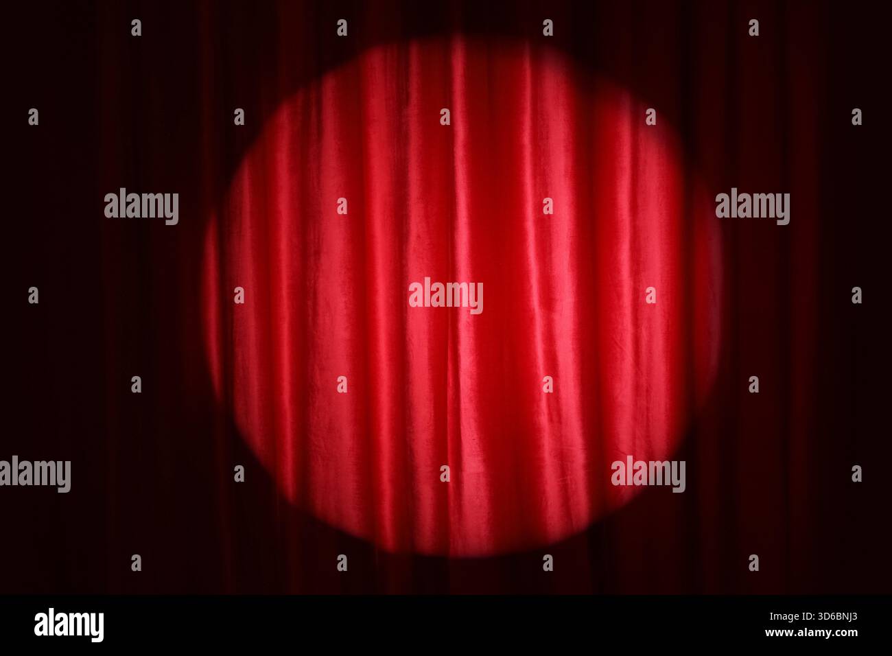 Shining spotlight on red curtain Stock Photo