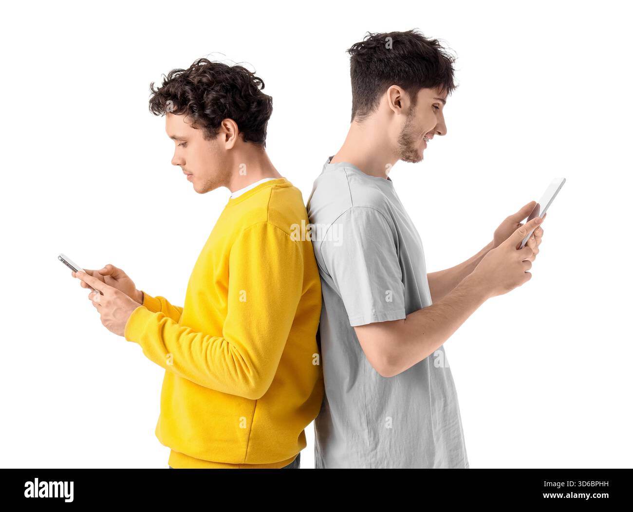 Young brothers using mobile phone and tablet computer on white background Stock Photo