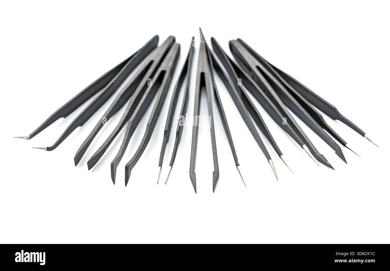 A collection of various black precision tweezers with metal tips is arranged in a semi-circle on a white background. Each tweezer has a different tip Stock Photo