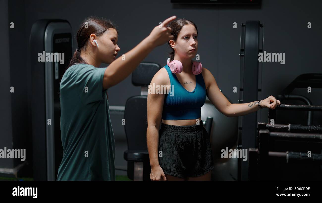 Professional personal trainer teaching proper exercise form to a woman ...