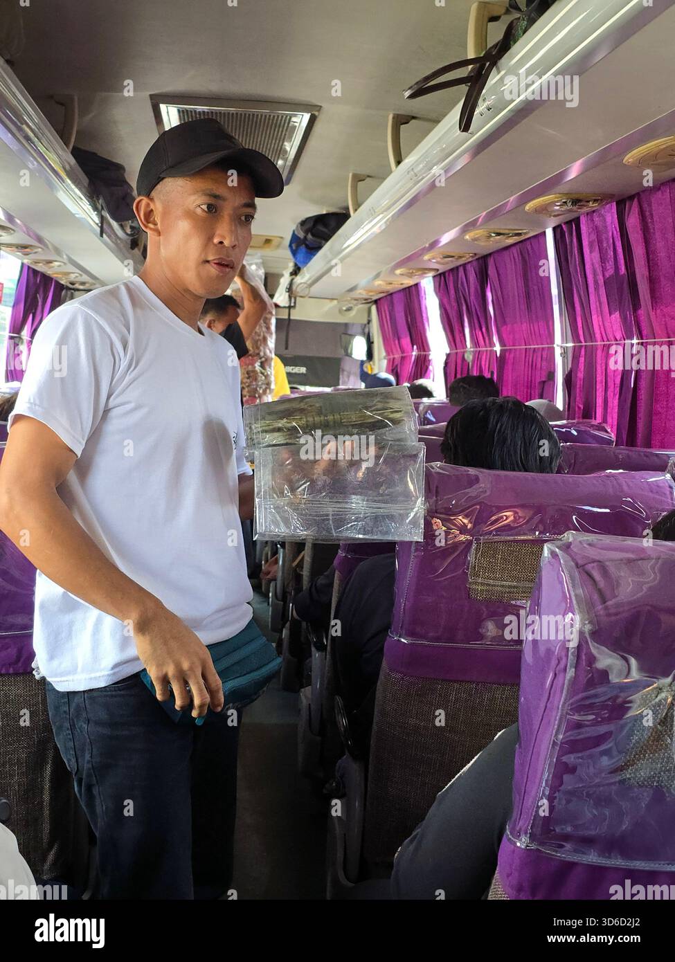 A Filipino man selling Chicharon Bagnet on a Coda Line bus in Luzon, Philippines. - Smartphone Captured Stock Image
