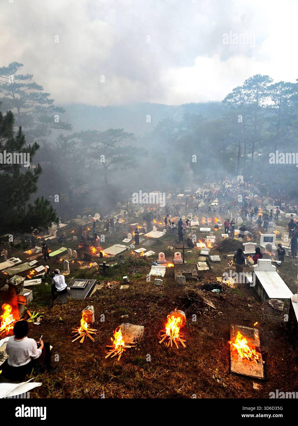 Families light bonfires at the grave of their ancestors at the night of All Saints Day / The evening of All Souls Day in Sagada, Luzon, Philippines. - Smartphone Captured Stock Image