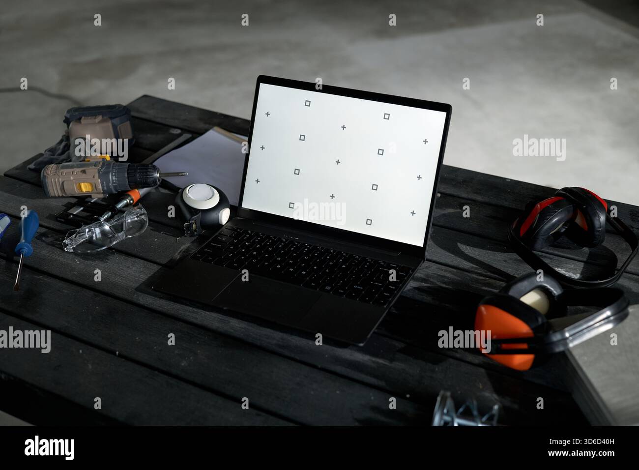 Laptop Displaying Calibration Screen Surrounded by Construction Tools on Table Stock Photo