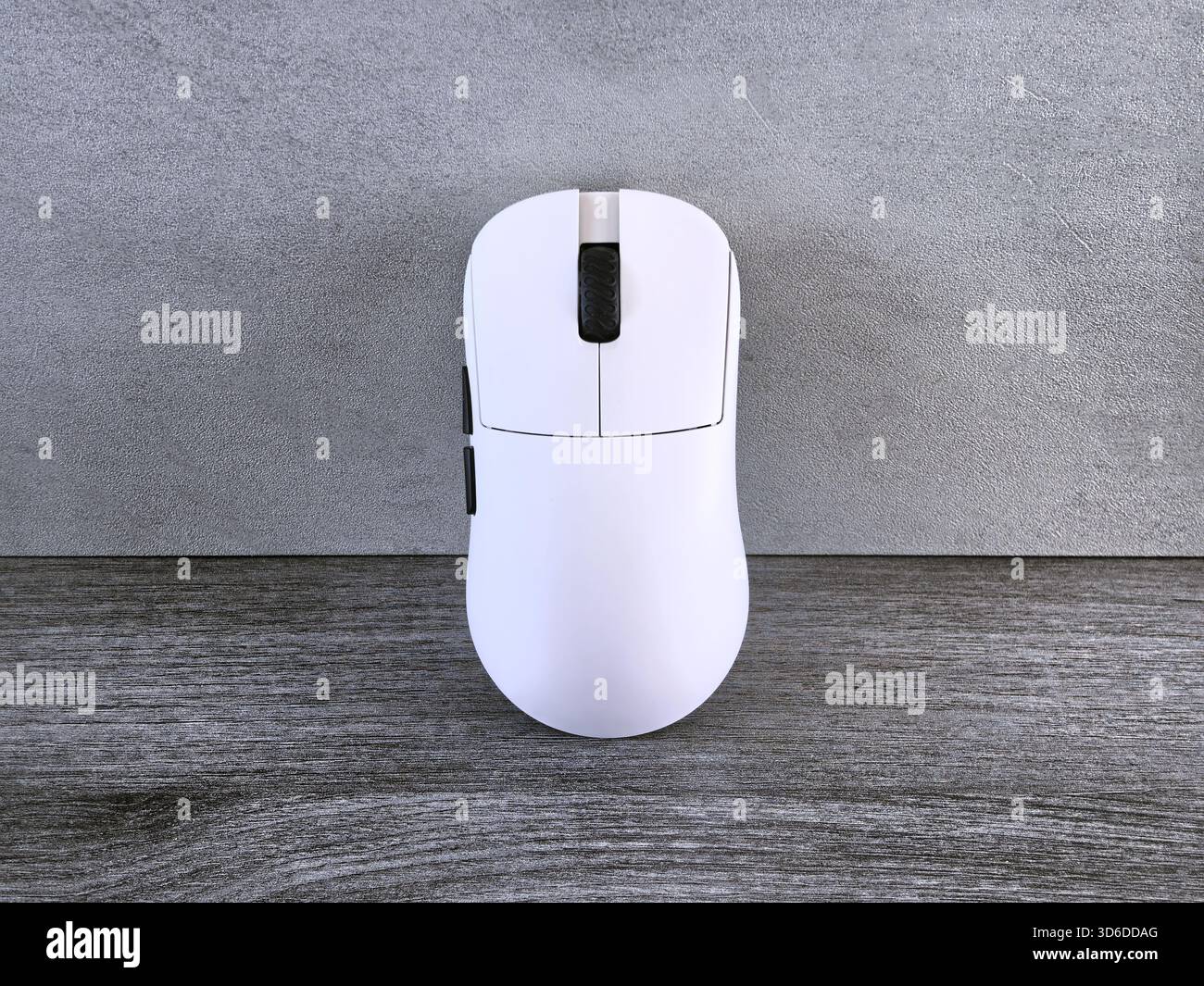 A sleek white gaming mouse poised for action ready to unleash digital prowess on a textured wood Stock Photo