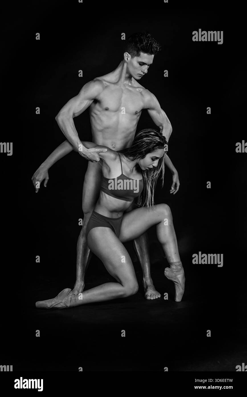 Black and white portrait of male and female ballet dancers striking elegant poses against a studio backdrop Stock Photo