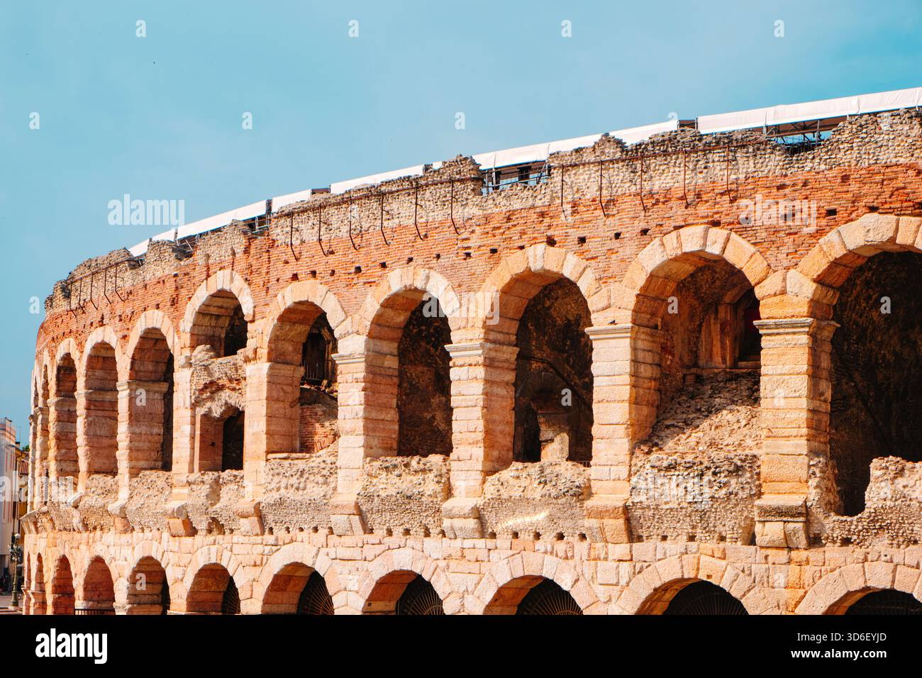 sunlit roman arches of the Arena di Verona, in Italy, as the ...