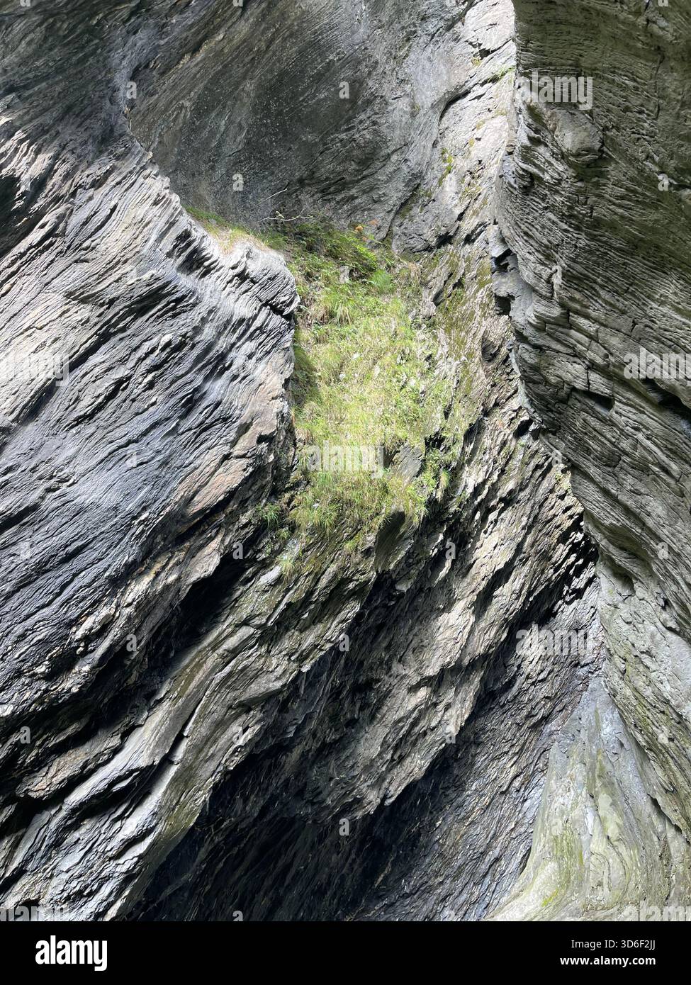 Close-up of rugged stone texture featuring a deep mountain crevice with weathered layers and natural details shaped by erosion over time long ago now. - Smartphone Captured Stock Image