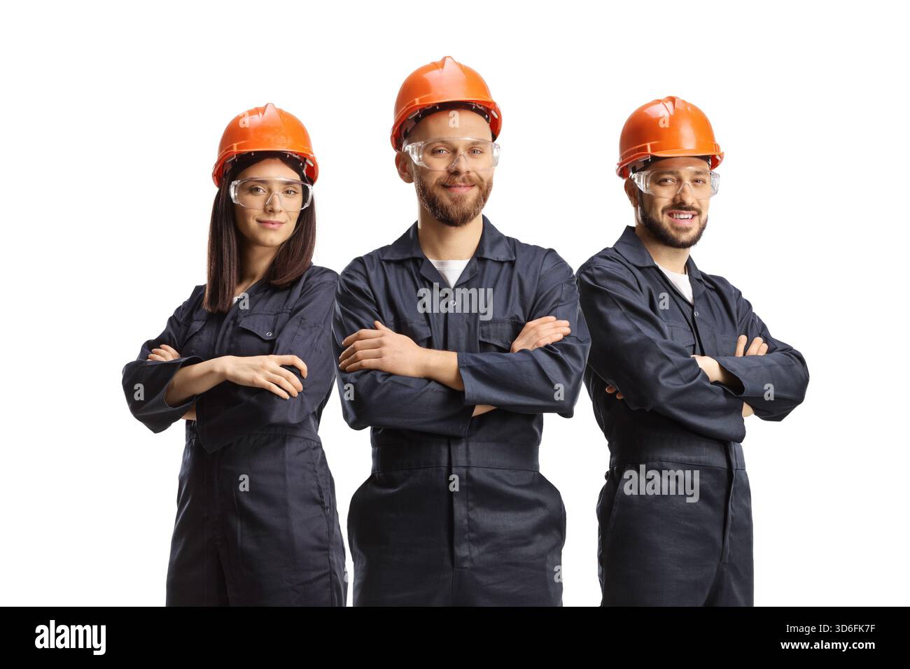 Team of factory workers in uniforms wearing helmets and goggles ...