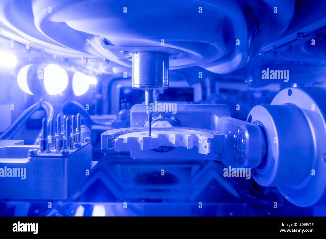 Automated dental milling machine carving zirconia crowns in CAD CAM system, illustrating high-precision digital dentistry, CNC prosthetic production, oral restoration technology, and modern dental lab workflow. Stock Photo