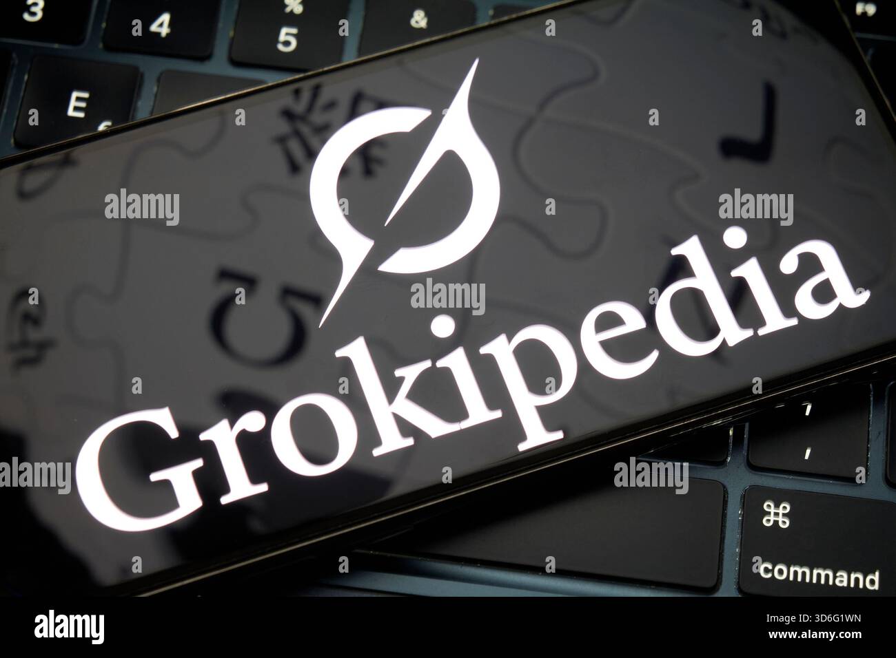 Grokipedia logo displayed on smartphone over computer keyboard Stock Photo