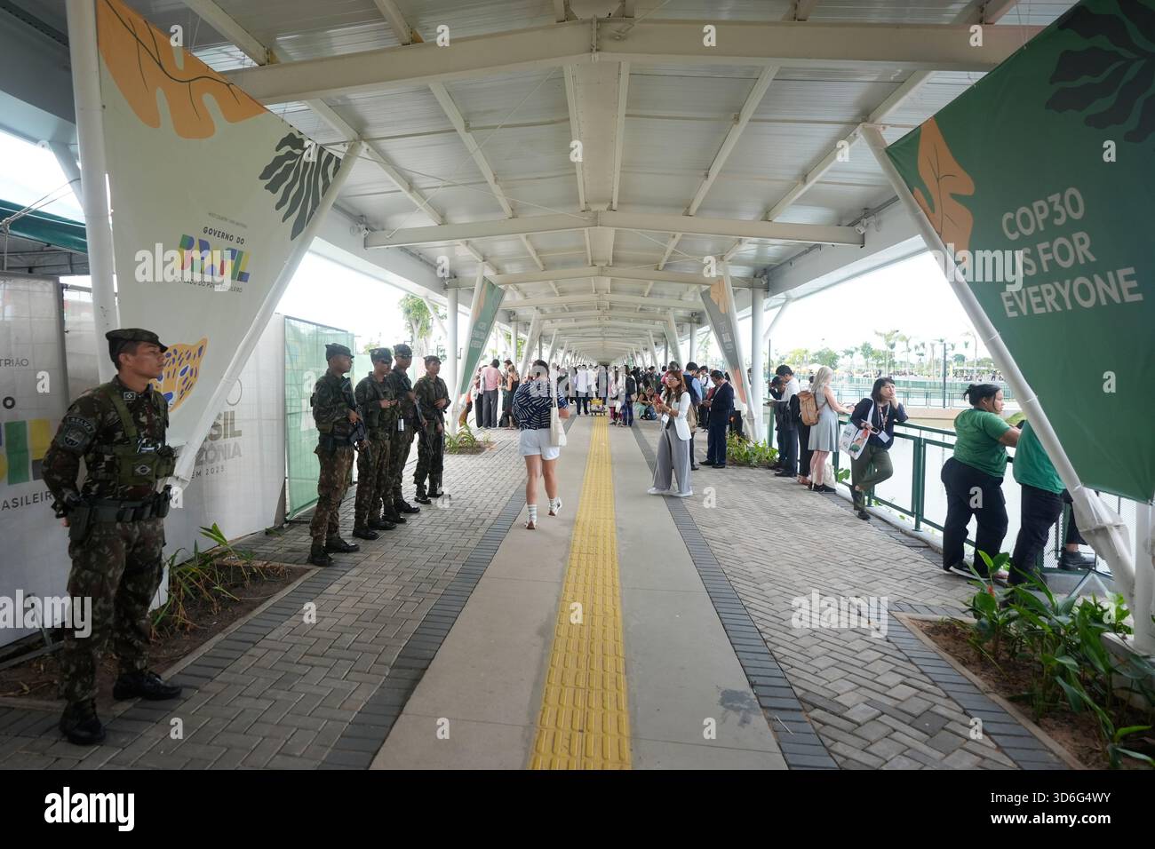 Security personnel and attendees stand outside the venue for the COP30 ...