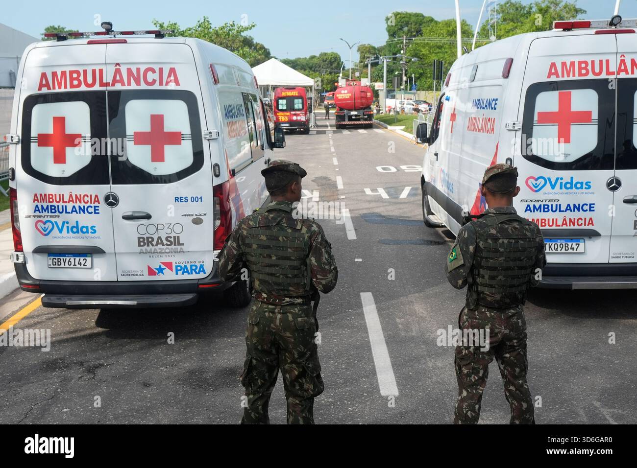 Security personnel stand guard by ambulances after a reported fire ...