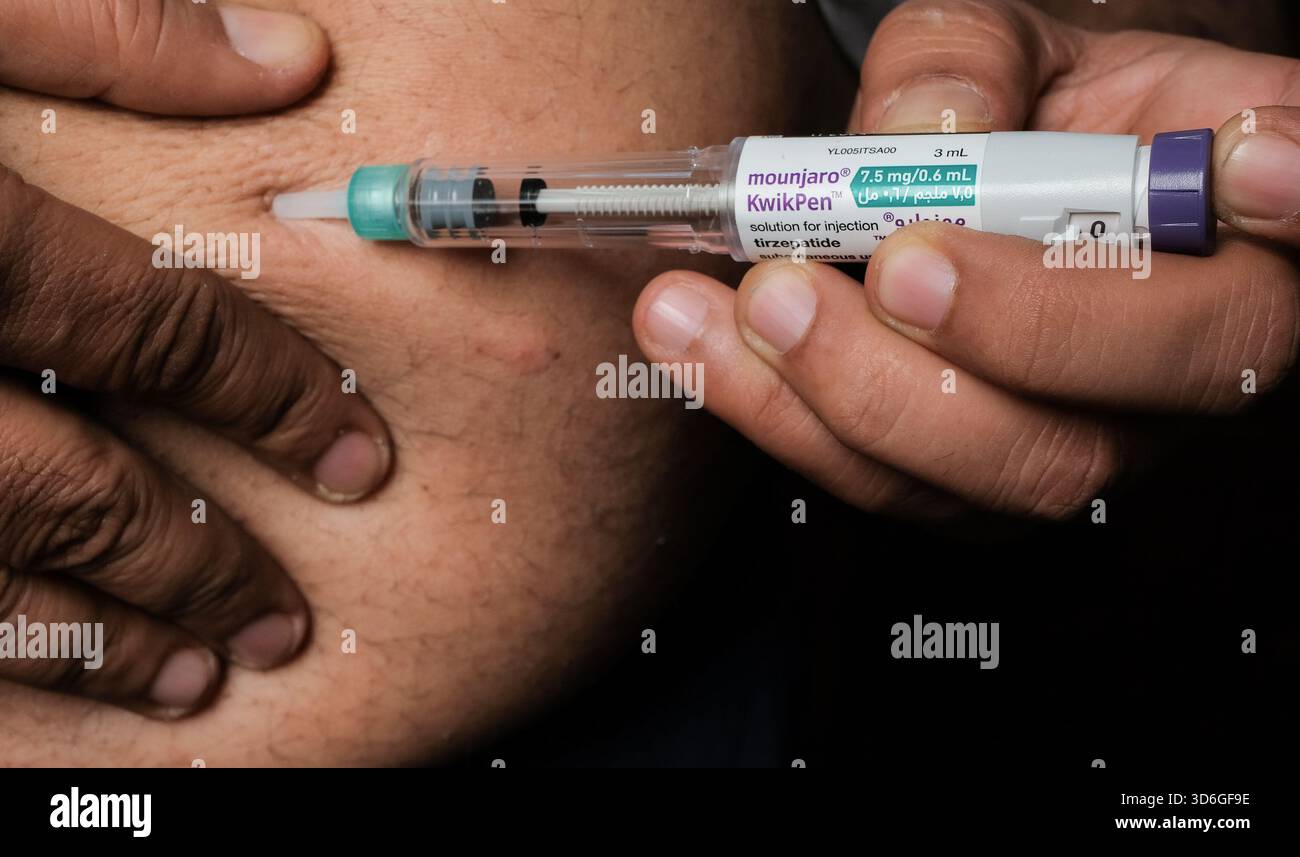 Close-up of a person injecting medication into their abdomen. Stock Photo