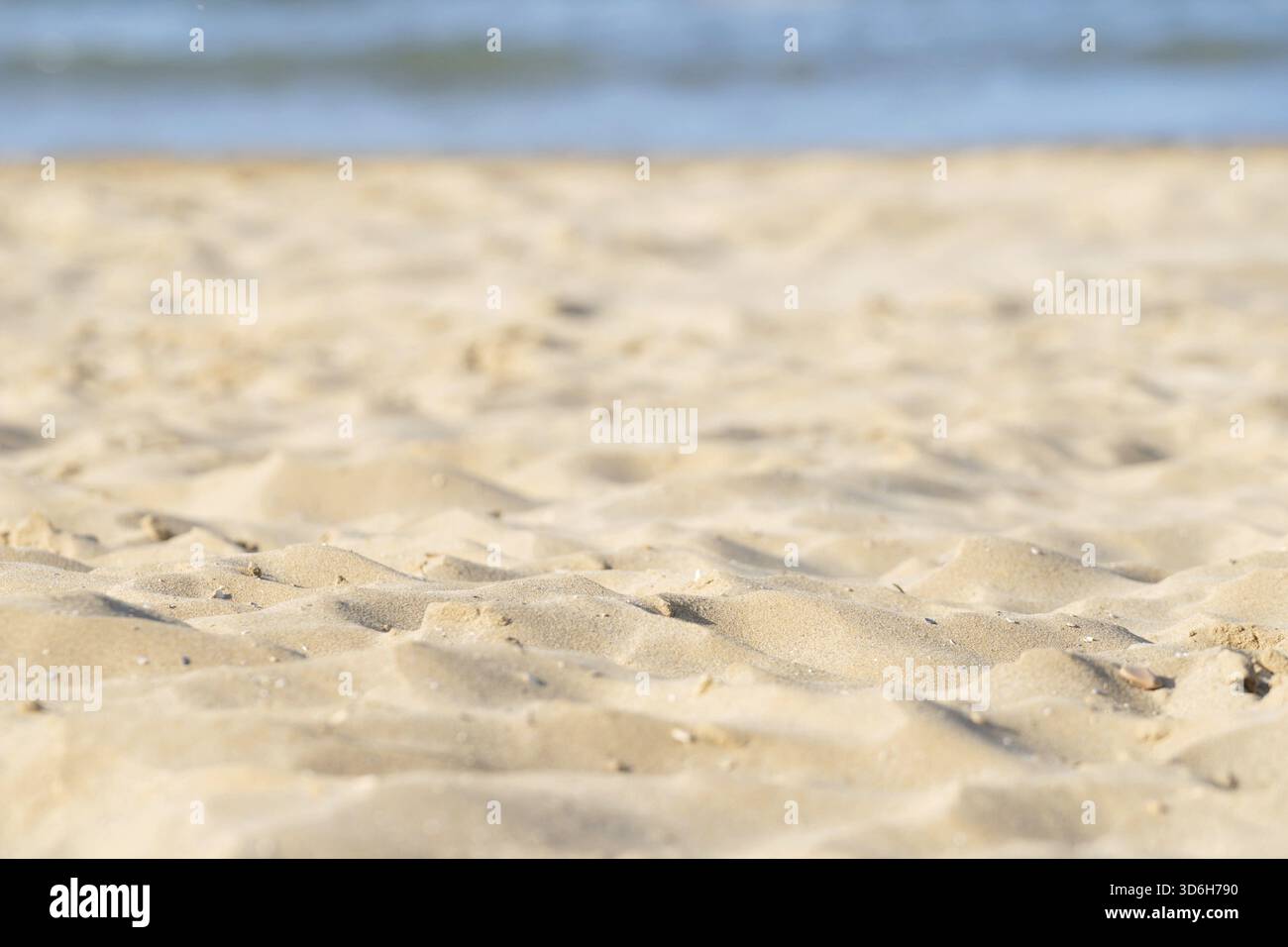 Closeup of sand pattern of beach in the summer. Sea water on background Stock Photo