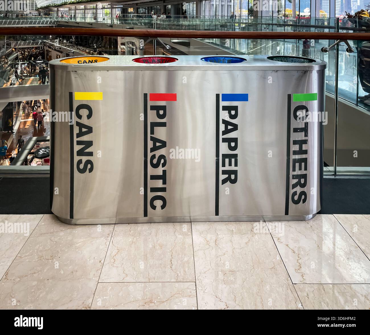 Modern multi-bin recycling station for cans, plastic, paper, and other waste in a busy indoor singapore shopping mall - Smartphone Captured Stock Image