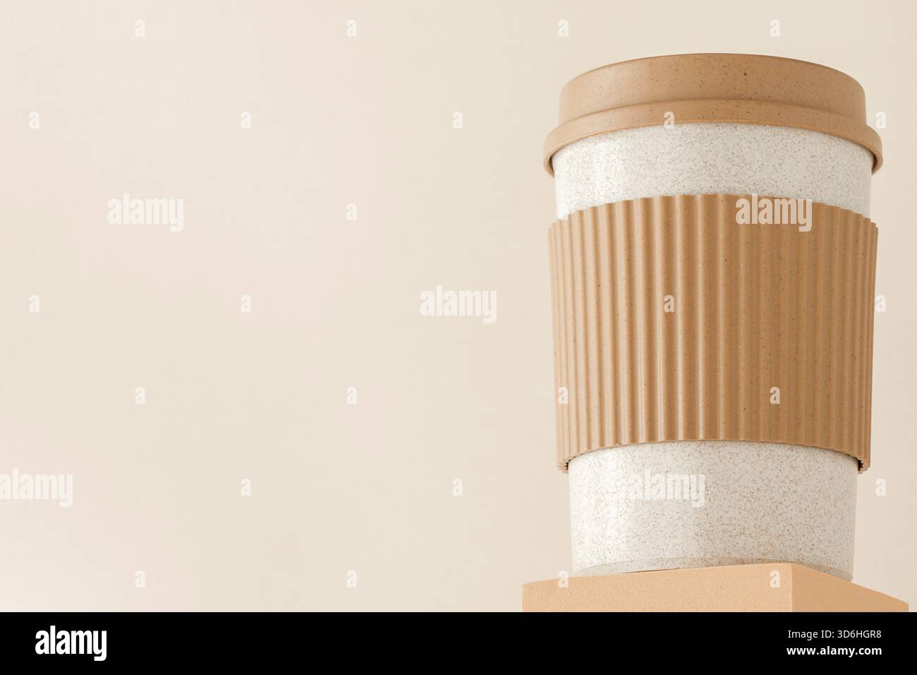 Reusable cup, biodegradable travel plastic coffee mug on platform showcase. Bamboo eco friendly cup on display pedestal. Zero waste, sustainability, s Stock Photo
