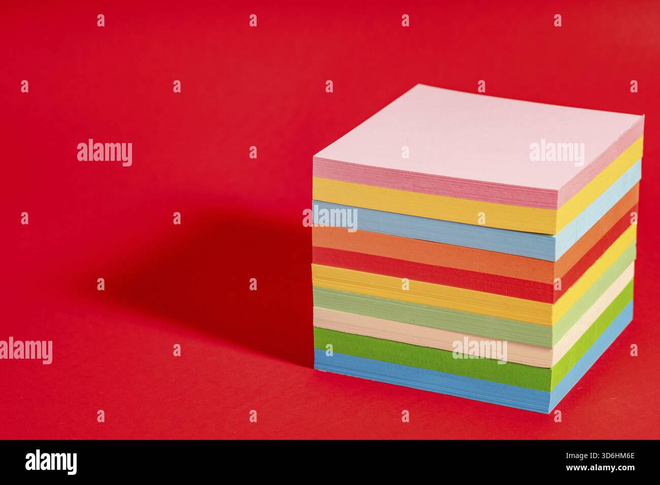 Stack of colorful sticky notes isolated on red background. Note block with memos Stock Photo