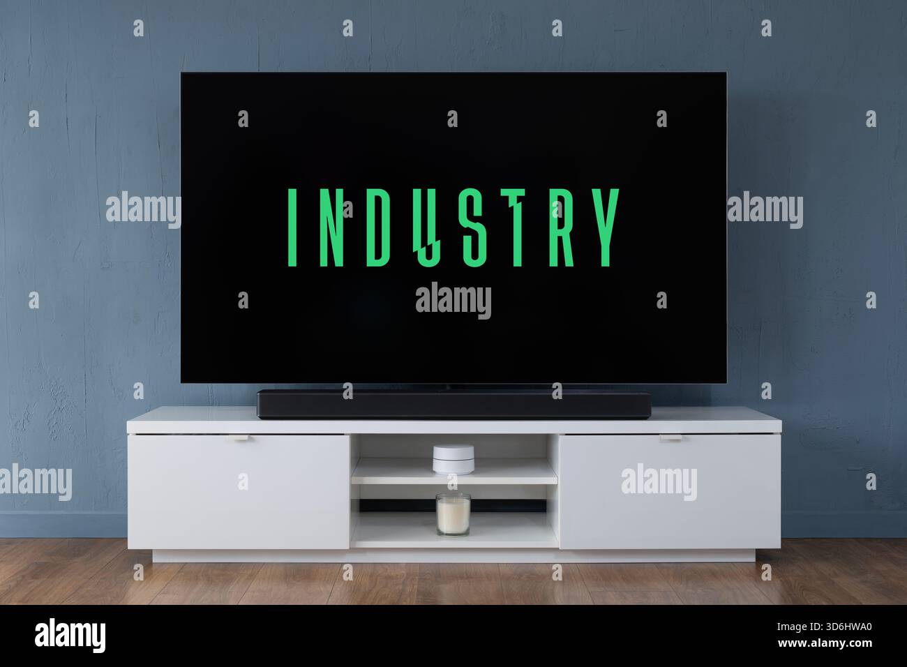 A widescreen OLED television showing the logo of the TV series Industry seen in a contemporary living room. Stock Photo