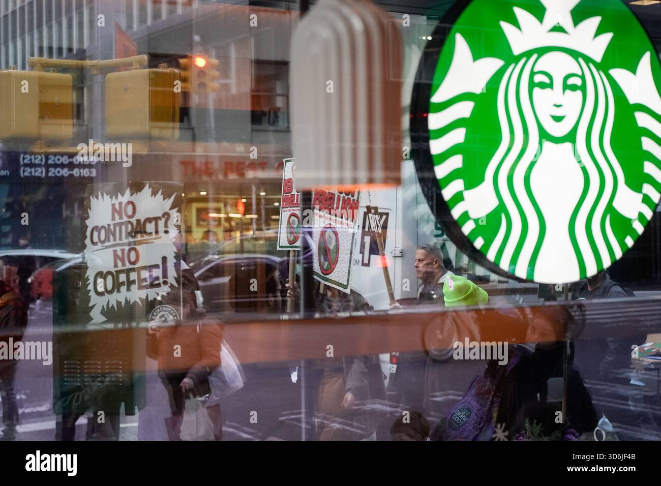 Starbucks baristas and employees picket outside a Starbucks storefront