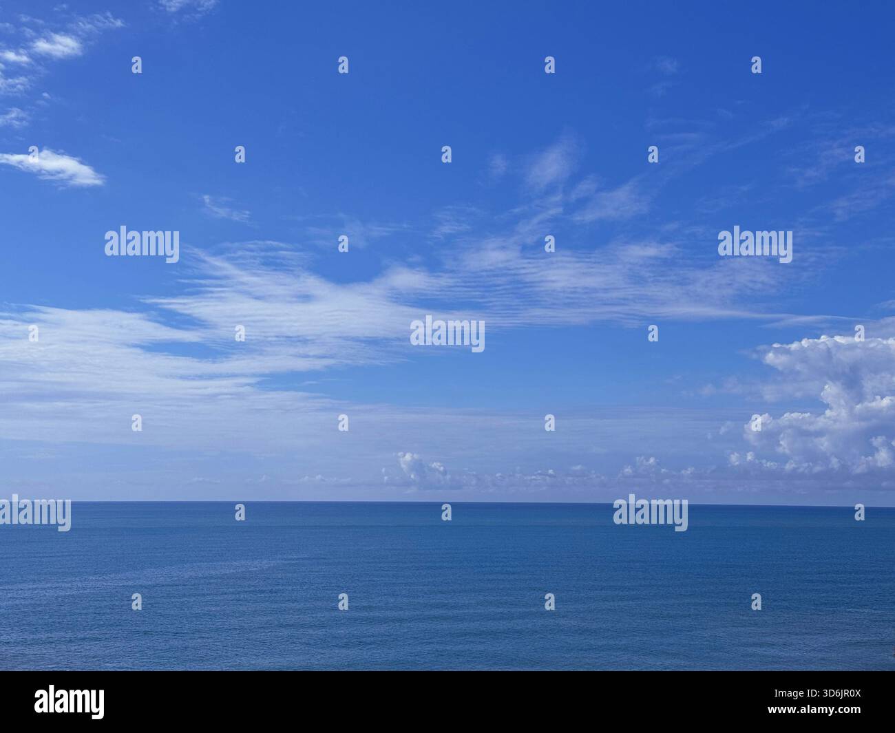 Calm sea blue water, blue sky, white clouds on horizon Stock Photo - Alamy