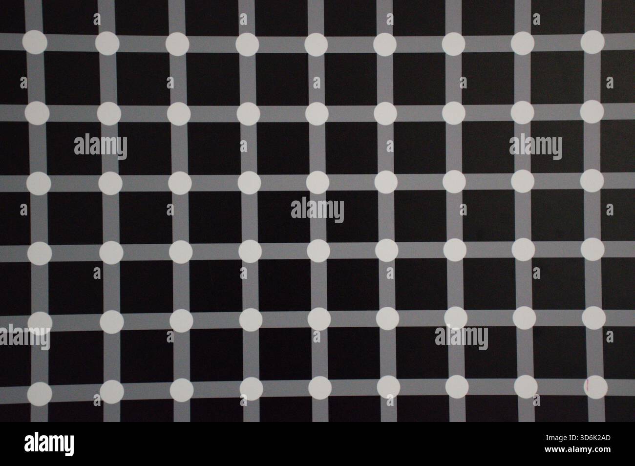 Abstract geometric pattern featuring a black background with intersecting gray lines and white dots, creating an optical illusion effect. Stock Photo