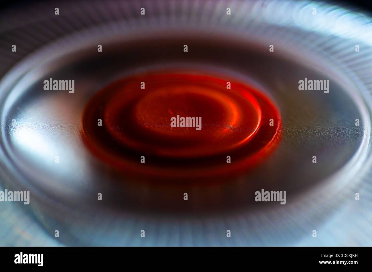 Intimate and abstract shot of a flashing emergency beacon, focusing on the vibrant red core with a radial plastic structure surrounding it. Artistic r Stock Photo