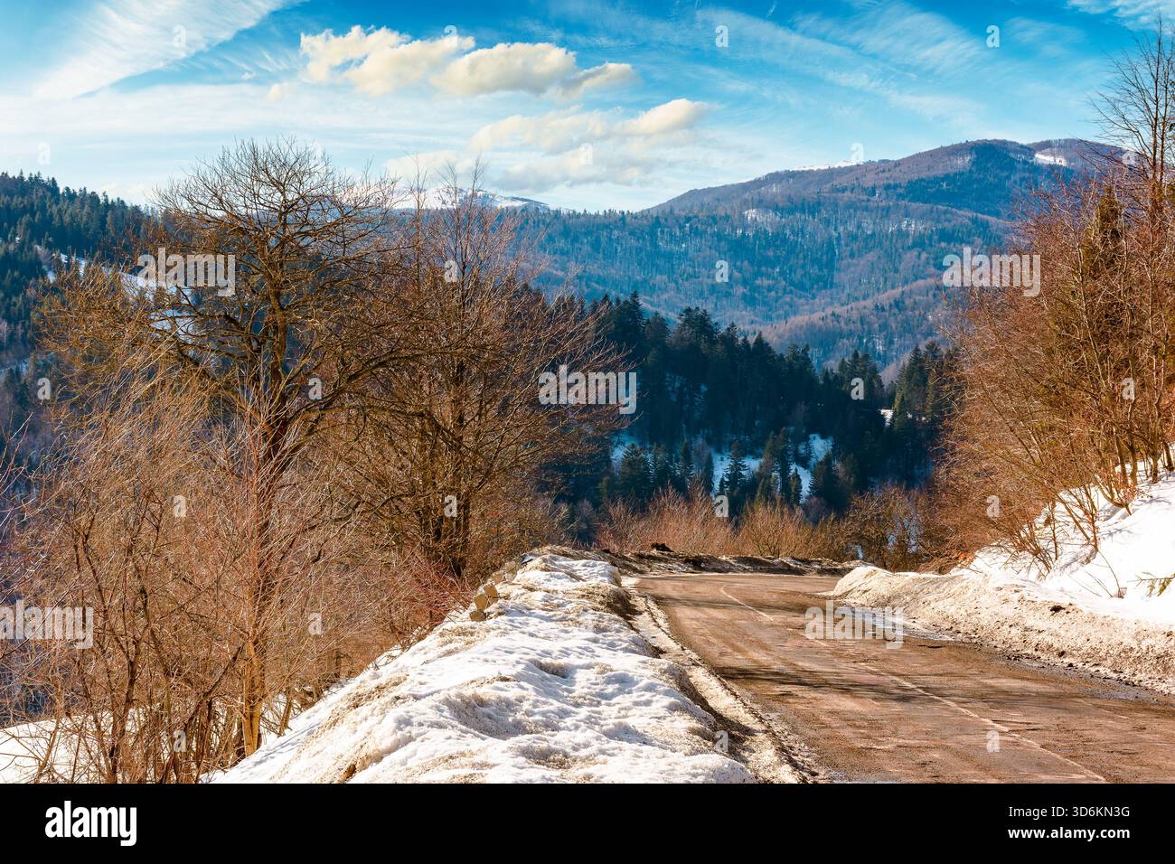 country road winding through winter landscape under blue sky. great bereznyi district of carpathian mountains on a sunny day. scenic view of uzhanian Stock Photo