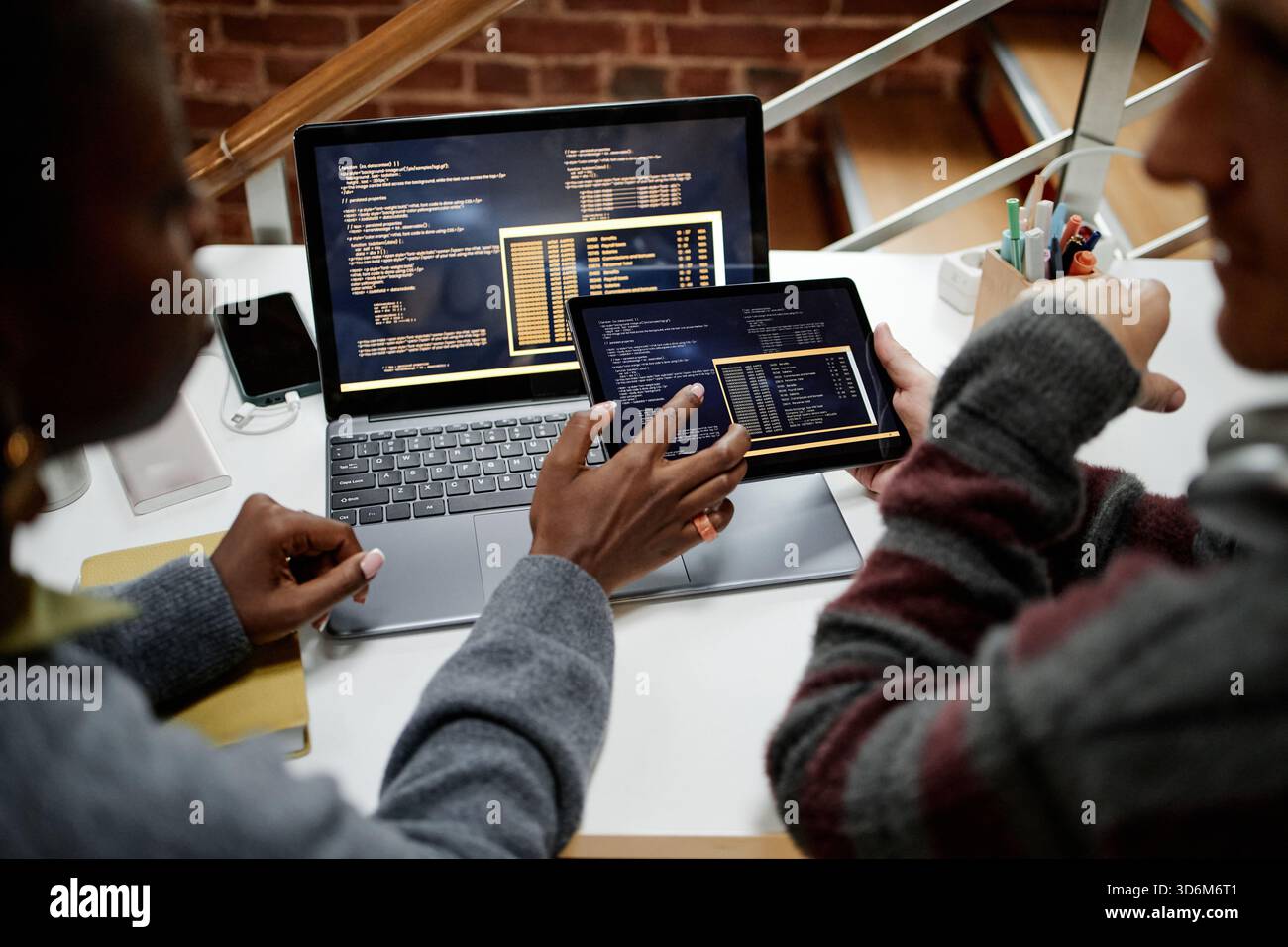 Young Adult Multiethnic Colleagues Collaborating on Software Development Project Stock Photo