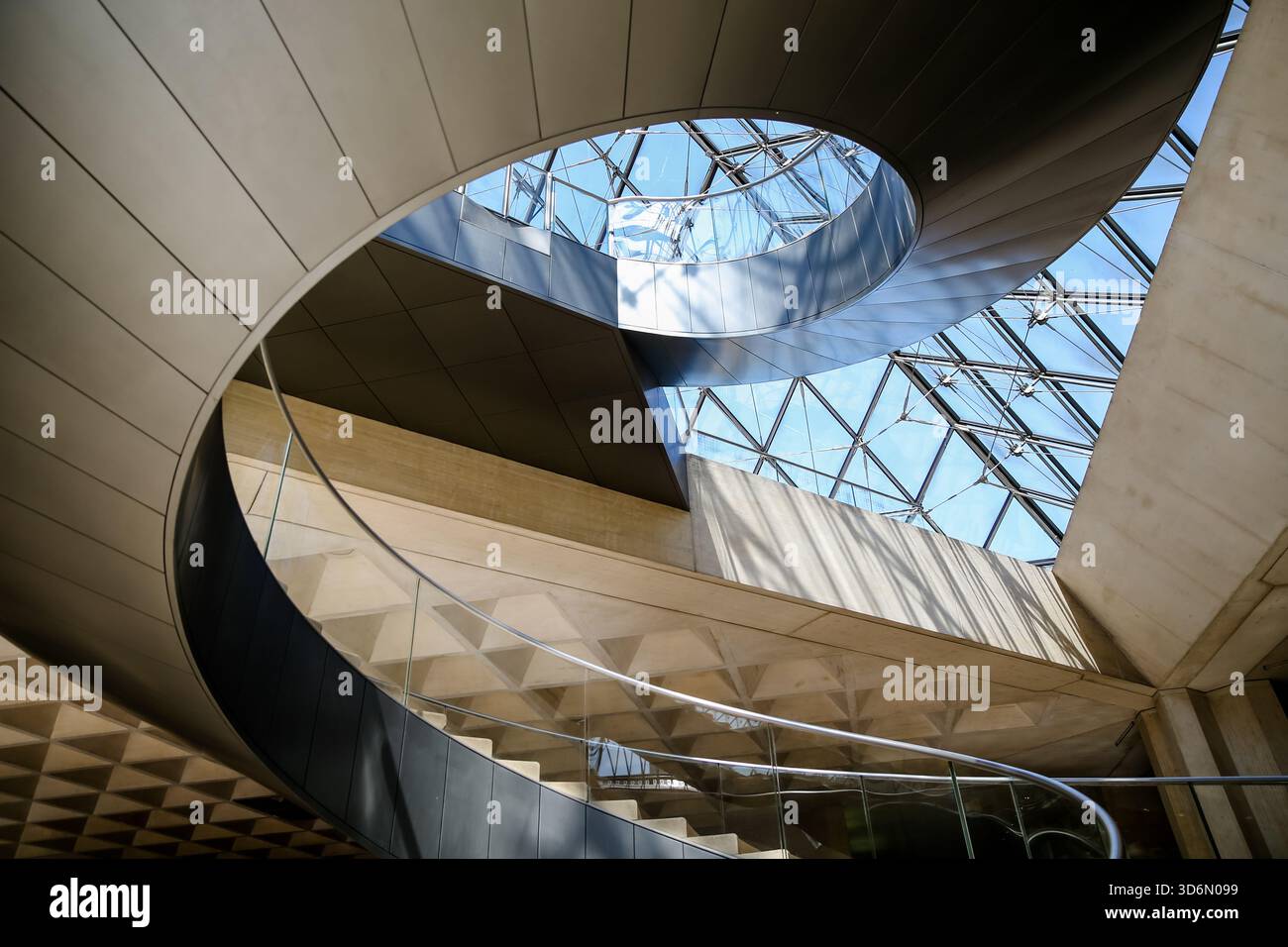 Visitors inside the Louvre Museum atrium in Paris walking beneath the ...