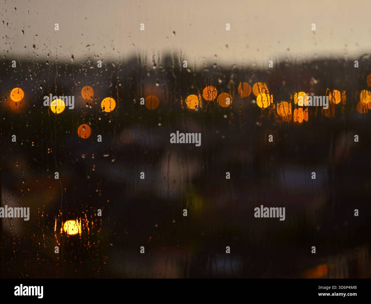 aindrops on the window in the evening. Bokeh illustration. Wallpaper or background. Stock Photo