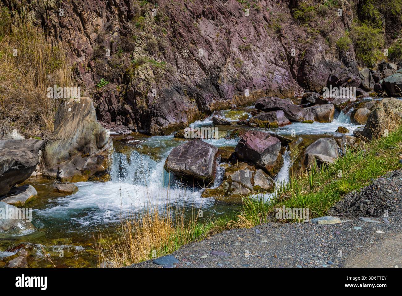 Serene river flowing through rocky mountainous landscape near gravel ...