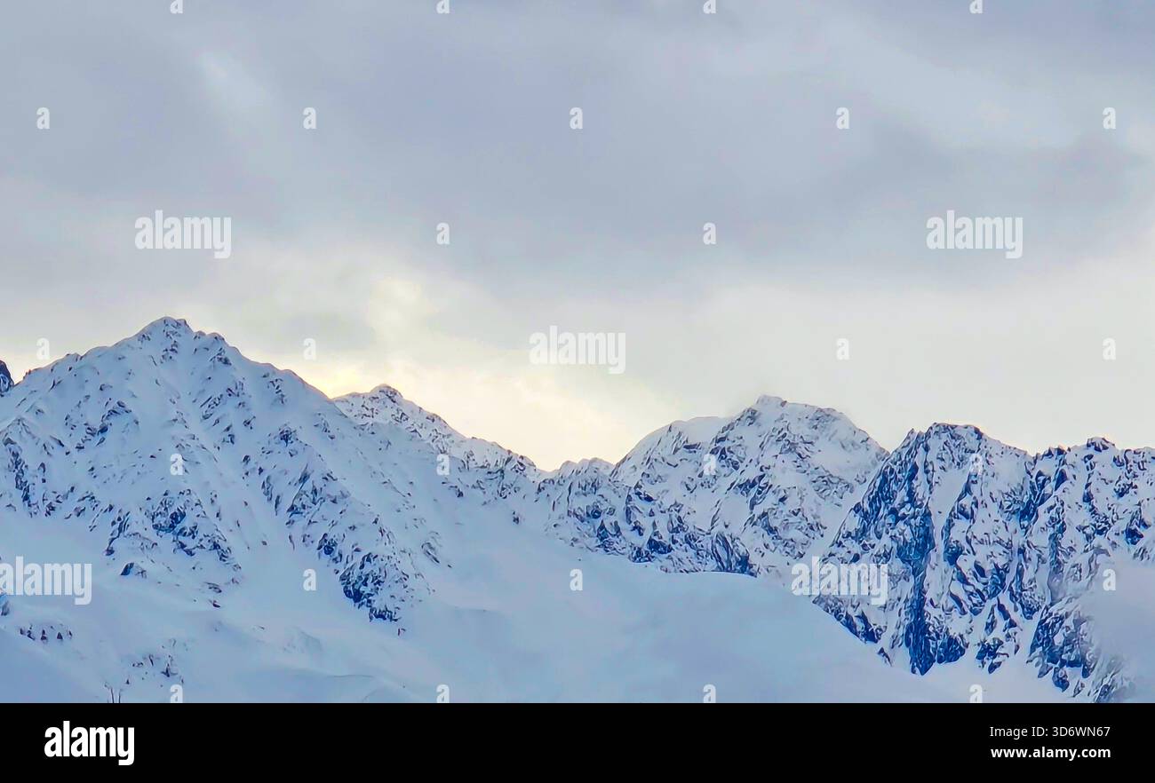 Snow-covered alpine peaks near Innsbruck, Austria, under a moody sky at ...