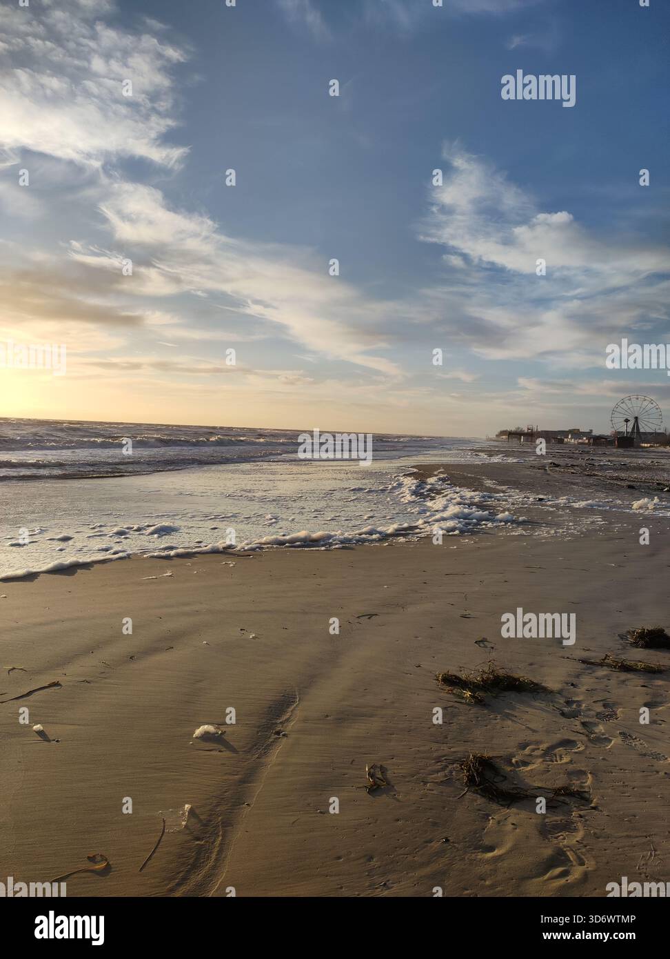 Calm sandy beach with waves at sunset,blue sky and gold sand - Smartphone Captured Stock Image