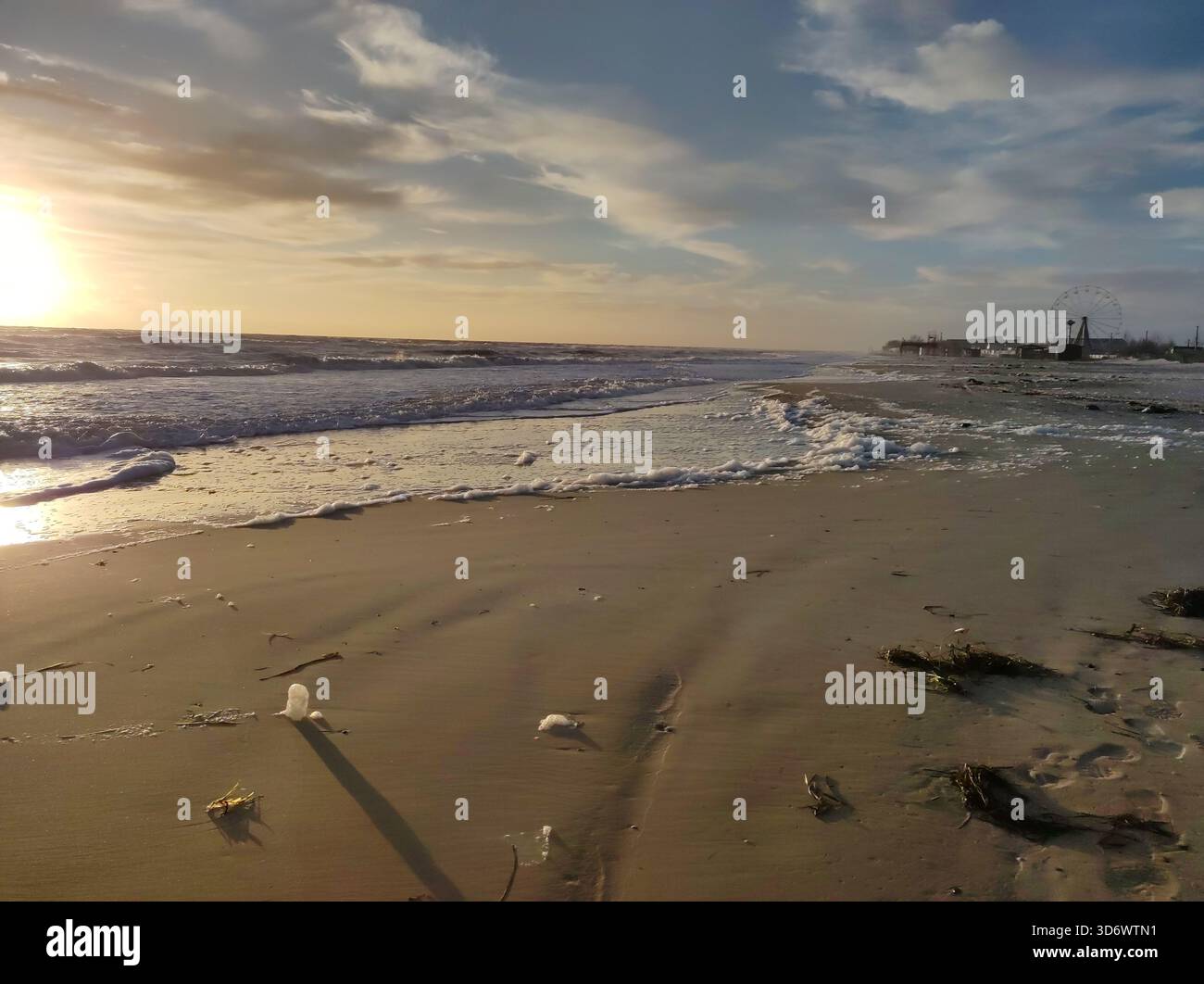 Calm sandy beach with waves at sunset,blue sky and gold sand - Smartphone Captured Stock Image