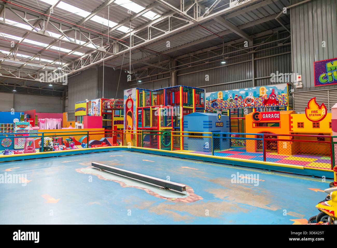 Documentary indoor children mini city play area featuring colorful themed structures like fire station, garage, police unit and activity zones. Stock Photo
