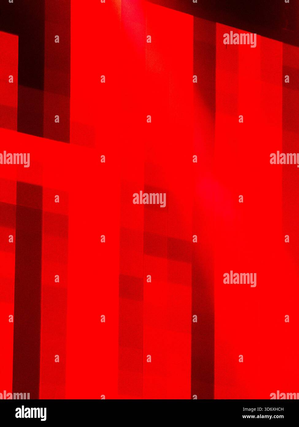 Abstract red geometric pattern creating a modern textured background with strong contrasts of light and shadow, offering a vibrant and dynamic visual Stock Photo
