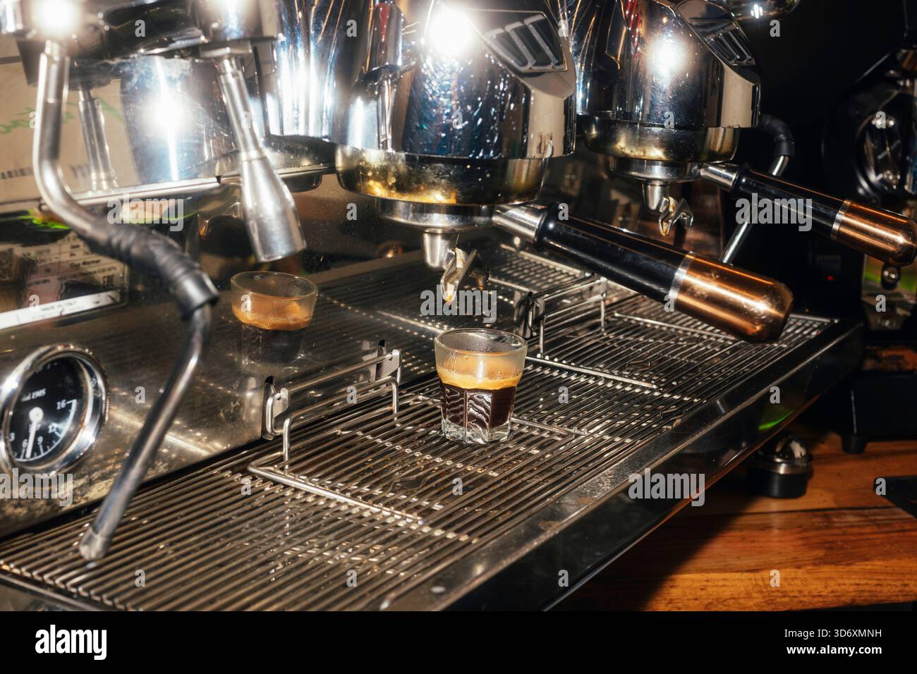 Espresso shot dripping from metal coffee machine Stock Photo - Alamy