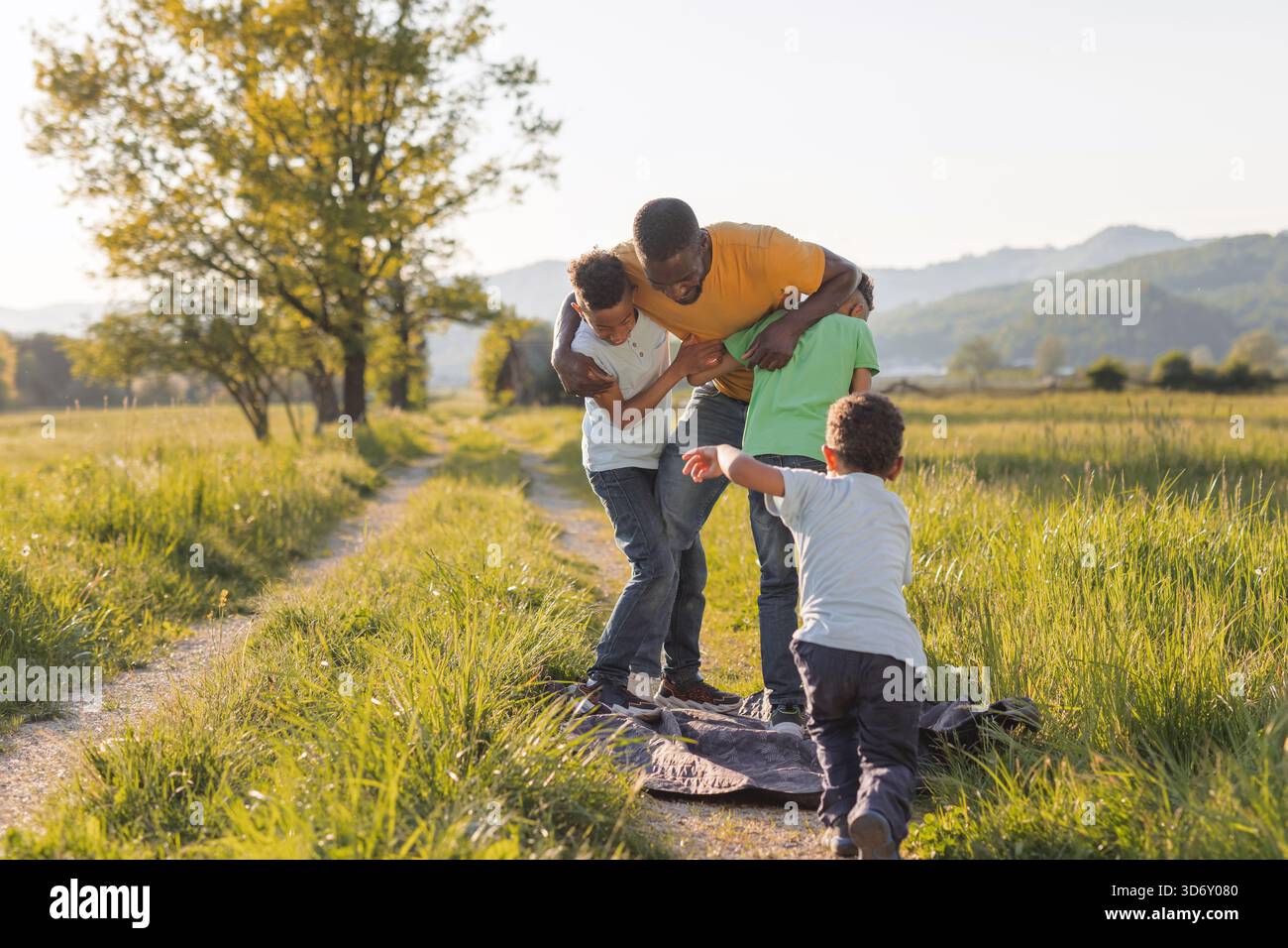 Three boys and their father enjoying fun, laughter, and playful ...