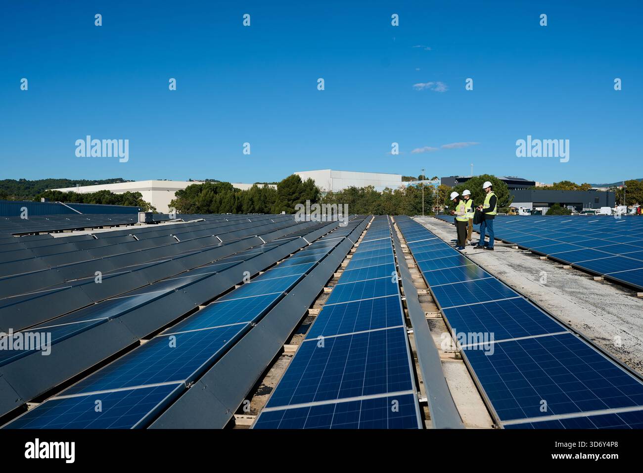 Engineers inspecting rooftop solar panel installation Stock Photo