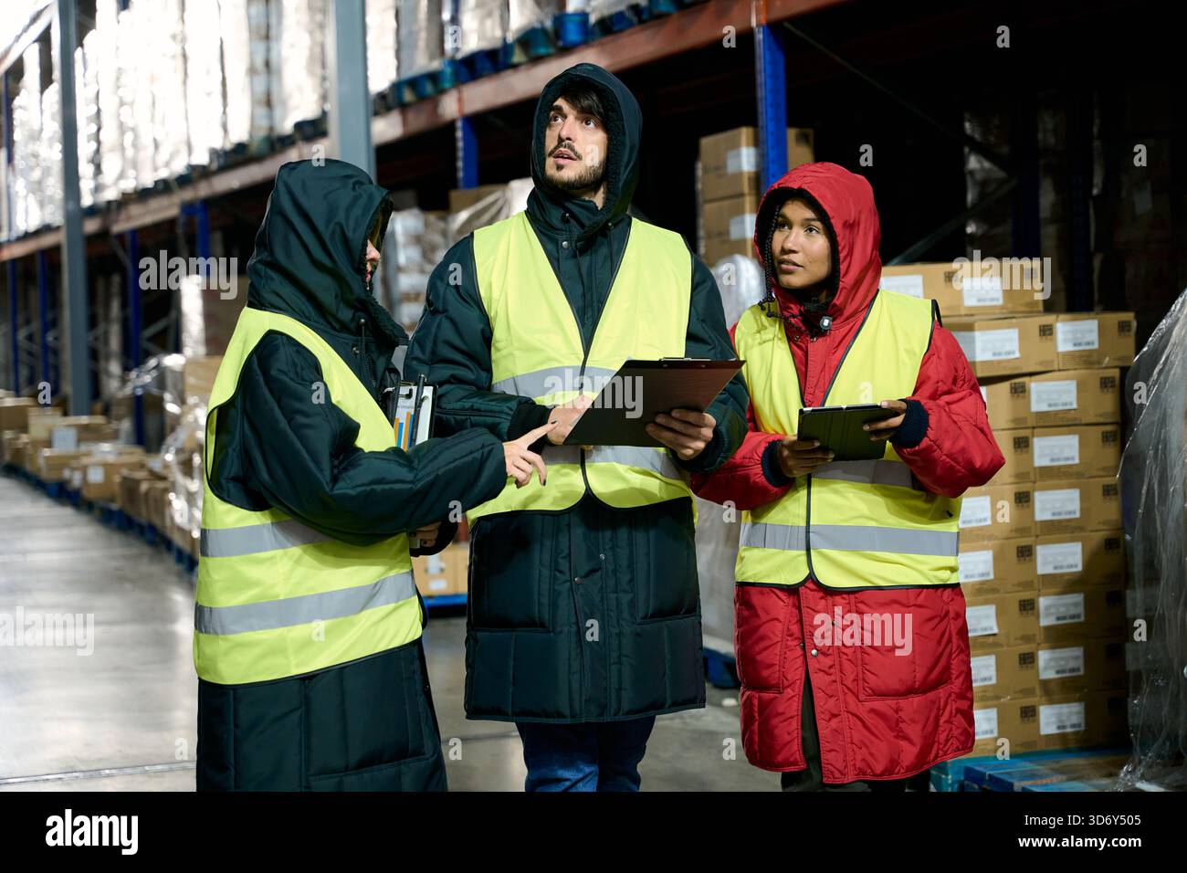Cold chain logistics team discussing inventory in warehouse Stock Photo