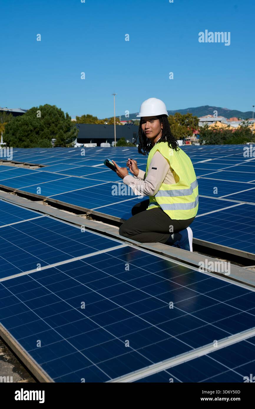 Woman engineer checking solar panels using digital tablet Stock Photo