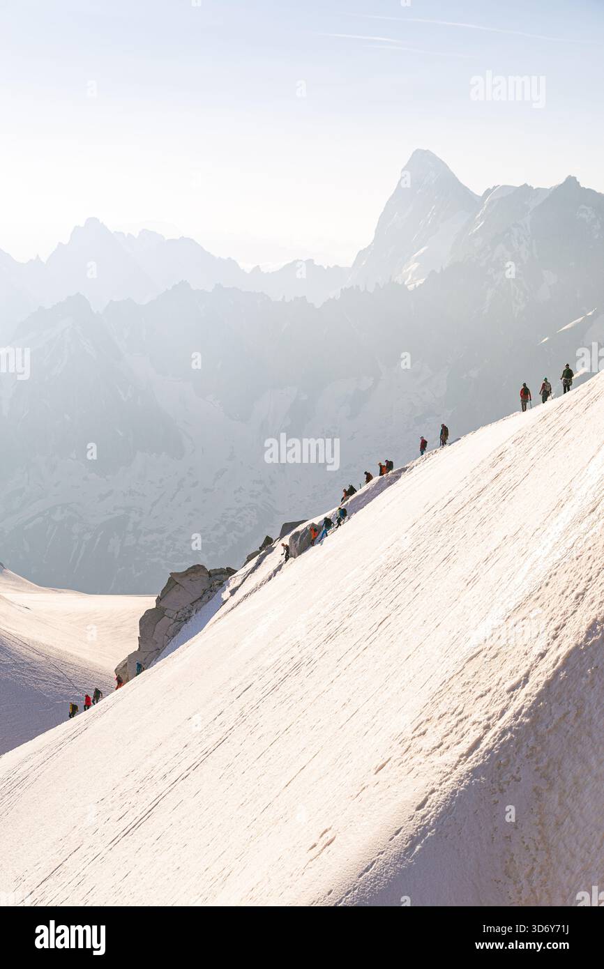 Snowy ridgeline on Aiguille du Midi above Chamonix with hikers crossing ...