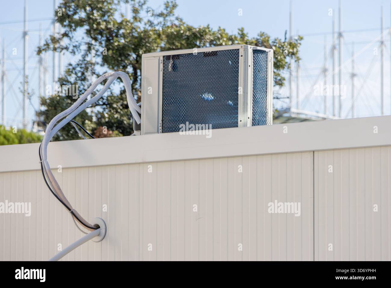 Outdoor air conditioner unit installed on a building wall with visible ...